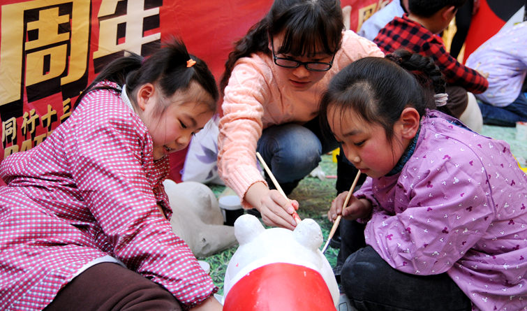 小朋友在藝術愛好者的指導下精心涂繪熊貓